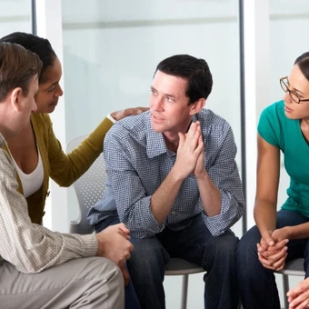 Grupo de quatro pessoas durante uma sessão de terapia